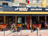 ein Restaurant mit orangefarbenen Tischen und Stühlen davor in der Unterkunft studio gabriel in Bastia