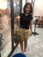 a woman standing in front of a window holding a bunch ofaments at Hungsen Homestay & Restaurant Cát Bà in Cat Ba
