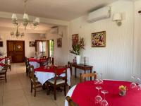 a dining room with two tables with red tablecloths at Hôtel Éden Roc Ivoire in San-Pédro