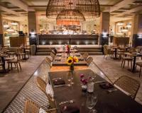 Un restaurante con mesas y sillas y una lámpara de araña. en Devossion By Live Aqua Playa del Carmen All Inclusive - Adults Only, en Playa del Carmen