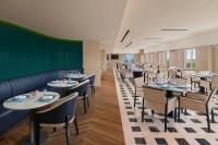 a dining room with tables and chairs and a green wall at Marriott Executive Apartments Bengaluru UB City in Bengaluru