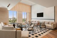 a waiting room with tables and chairs and a flat screen tv at Marriott Executive Apartments Bengaluru UB City in Bengaluru