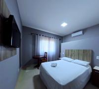 a bedroom with a bed and a television and a table at Plaza Hotel Sinop in Sinop