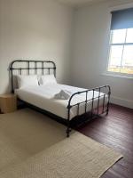 Un dormitorio con una cama con sábanas blancas y una ventana. en Echuca Hotel, en Echuca