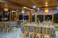 a dining room with tables and chairs and windows at Cloud Valley Háng Đồng in Bắc Yên