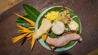 a plate of food with meat and salad on a table at Finca Agroturística Rosita in San Luis de Palenque