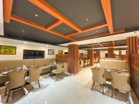 uma grande sala de jantar com mesas e cadeiras em Maramon Hotel & Resort em Pathanāmthitta