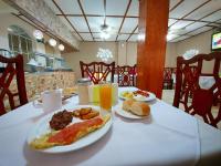 uma mesa com um prato de comida de café da manhã e suco de laranja em Hotel Continental Plaza em San Miguel