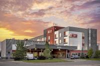 a building with cars parked in a parking lot at Best Western Plus East Side in Saskatoon