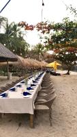 a long row of tables on a beach at Villa Sundancer Lombok By Mey, Ocean View Villa with Infinity pool in Pulau Gilipoh