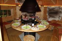 a table in a cabin with wine glasses on it at Les Cabanes De Pyrene in Cazarilh