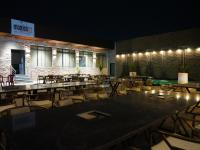 un restaurante vacío con mesas y sillas por la noche en Enrise By Sayaji, Kalaburagi, en Gulbarga