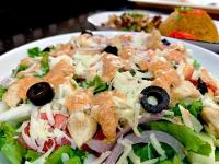 a salad on a white plate on a table at 5 Star Villa Hotel in Accra