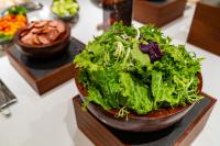 Una ensalada en un bol en un plato sobre una mesa. en YUNlK Hotel Harbin Central Street Sophia Cathedral, en Harbin