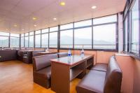 BaudhatinchuleHotel Om的餐厅设有桌椅和大窗户