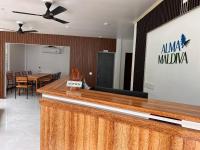 Eine Bar in der Lobby mit einem Tisch und Stühlen in der Unterkunft Alma Maldiva, Beach Hotel in Ariyaddu