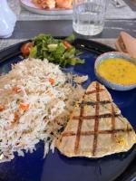 ein blauer Teller mit Reis und Fleisch und eine Schüssel Suppe in der Unterkunft Alma Maldiva, Beach Hotel in Ariyaddu