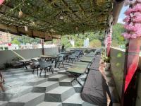 Un restaurante con mesas y sillas y suelo de cuadros. en Yatram, en Rishīkesh