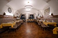 comedor con mesas y sillas y reloj en Hotel Arkada, en Levoča