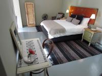 a bedroom with a large bed and a table with a table sidx sidx at Caledon 31 in George