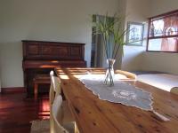a dining room table with a vase on it with a piano at Caledon 31 in George