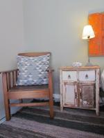 a room with a chair and a table with a lamp at Caledon 31 in George