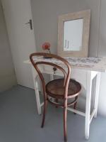 a chair sitting in front of a desk with a mirror at Caledon 31 in George