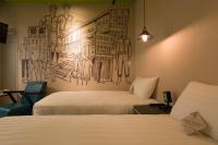 a room with two beds and a mural on the wall at Cho Hotel in Taipei
