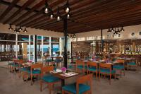 Un restaurante con mesas y sillas de madera y ventanas. en Altitude by Krystal Grand Los Cabos - All Inclusive, en San José del Cabo
