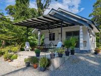 a house with a patio with chairs and plants at Homestay Tepi Sungai Perak in Kuala Kangsar