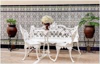una mesa blanca, 2 sillas y una mesa con flores en Pension Azahar, en Sevilla