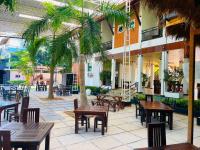 Un patio con mesas y sillas y palmeras. en Even Beach Oasis, en Wayikkal