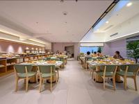 um restaurante com mesas e cadeiras e pessoas a comer em 西安万蒙酒店 em Xian