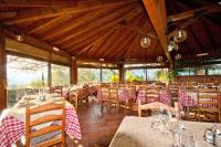 a restaurant with tables and chairs with red and white tablecloths at Agriturismo Monterosso in Verbania