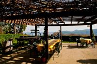 a group of tables and chairs under a wooden pergola at Agriturismo Monterosso in Verbania