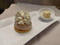 Un pastel en un plato blanco con un tazón de helado en Hôtel La Rivière, en Entraygues-sur-Truyère