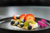 un plato con ensalada de frutas en una mesa en Palladium Business Hotel, en Montevideo