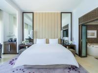 Un dormitorio con una gran cama blanca y un baño. en Rixos Marina Abu Dhabi, en Abu Dabi