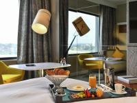 Una habitación de hotel con una bandeja de comida en una cama. en Pullman Abidjan, en Abiyán