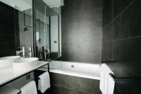 a bathroom with two sinks and a bath tub at Atypik Hotel in Clichy