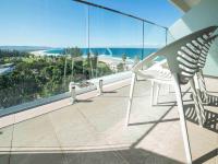 Una silla en un balcón con vista al mar. en Novotel Wollongong Northbeach, en Wollongong