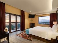 a hotel room with a bed and a large window at Mercure Padang in Padang