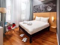 una habitación de hotel con una cama y una silla en ibis Edinburgh Centre South Bridge – Royal Mile, en Edimburgo
