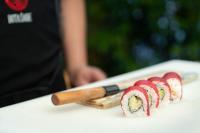 Eine Reihe Sushi auf einem Tisch mit einem Messer in der Unterkunft Flex SelfCheckIns 98 - Zagreb - 2 Bedrooms - Parking - Loggia in Velika Mlaka