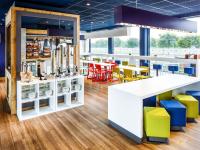 Un restaurante con sillas y mesas amarillas y azules. en ibis budget Hotel Edinburgh Park, en Edimburgo