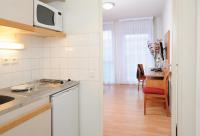 a kitchen with a sink and a microwave above a counter at Séjours &amp; Affaires Paris Ivry in Ivry-sur-Seine