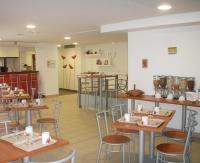 a restaurant with tables and chairs and a kitchen at Séjours &amp; Affaires Paris Ivry in Ivry-sur-Seine