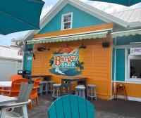 a building with a burger shack with tables and chairs at Blue Wave Suites in Clearwater Beach