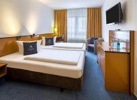 a hotel room with two beds and a television at Aspire Frankfurt Airport, Trademark Collection by Wyndham in Rüsselsheim