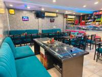 Un comedor con mesas y sillas y una piscina. en Punjabeez Restaurant, en Patiala